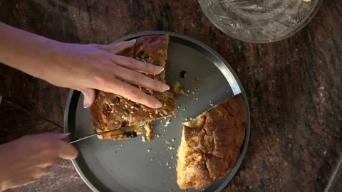Hands slicing seeded sponge cake from above Stock Footage 345661152
