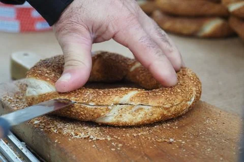Hands slicing simit bread at a market in Istanbul Stock Photos