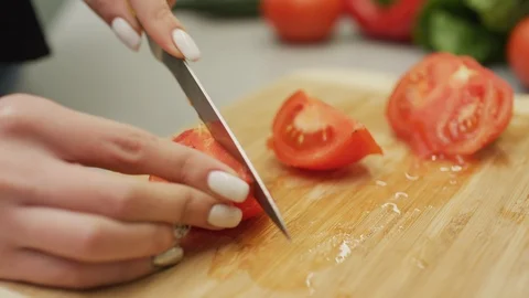 Hands slicing tomatoes Stock Footage 99940377