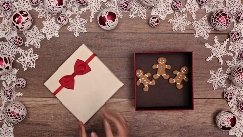 Hands slipping a christmas present box inside a seasonal decorations frame Video stock 81169955