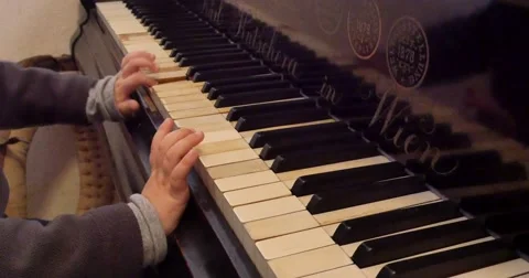 Hands of small boy trying to play few notes on old piano in 4K Stock Footage 43556384