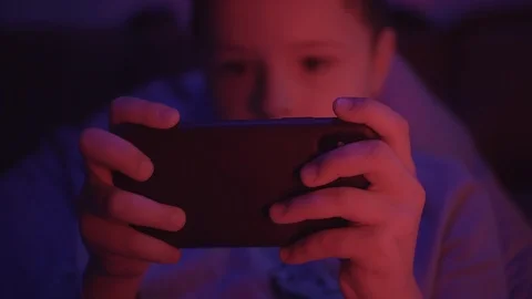 Hands small boy use smartphone before going to bed in a dark room play games Stock Footage 127168619