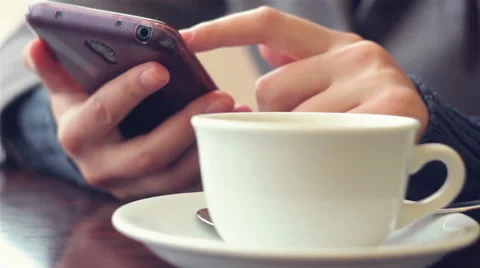 Hands on a smartphone near cup of coffee Stock Footage 59773056