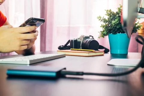 A Hands with smartphone working on computer at her home office Stock Photos