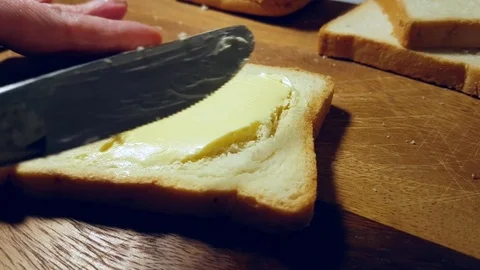 Hands smear butter on bread Stock Footage 83952489