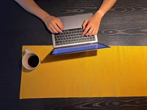 Hands software developer, view from above. Background yellow tablecloth Foto stock