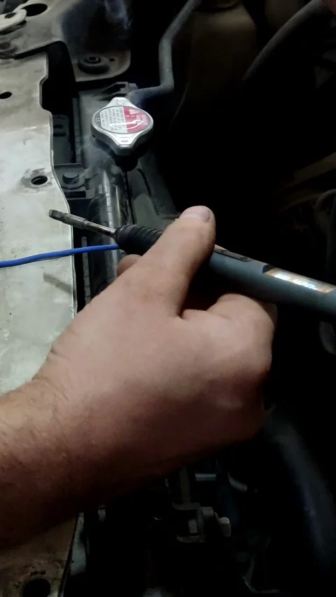 Hands soldering blue wires with a digital iron and smoke Stock Footage 333701871