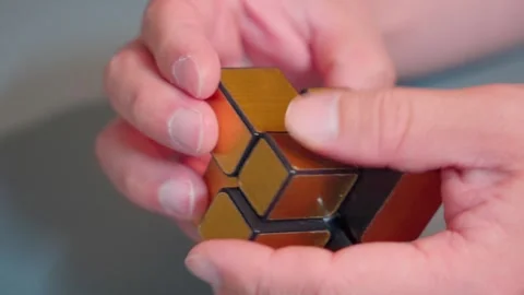Hands Solving Golden Mirror Cube Puzzle Close Up 4K Stock-Footage 340179072
