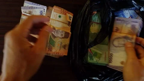 Hands sort cash against dark background Vidéo 332335542