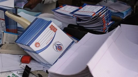 Hands sorting and stacking printed notebooks 動画素材 326936166