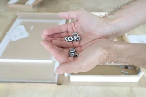 Hands Sorting Metal Nuts and Washers for Furniture Assembly DIY Process 写真素材