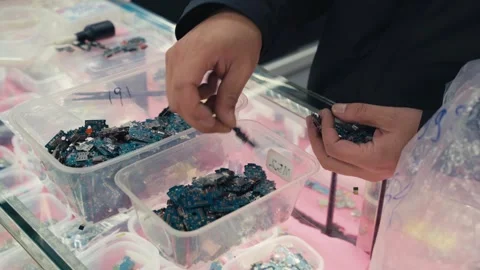 Hands sorting smartphone circuit boards in electronics components parts shop 動画素材 328951147