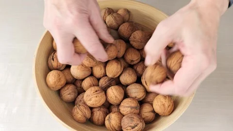 Hands sorting whole walnuts in a wooden bowl. Stock Footage 327113700