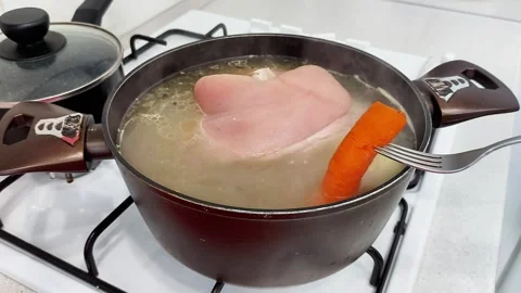 Hands-On Soup Making: Fork-Lifted Carrot from Boiling Pot Stock Footage 320600568
