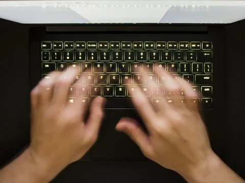 Hands speedtyping on a backlit keyboard Stock Photos