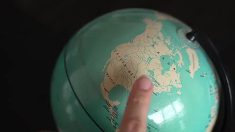 Hands Spinning a Globe and Pointing to the United States with a Finger Видео 304337451