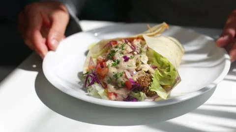Hands spinning plate with vegetable wrapped roll Stock Footage 265987950