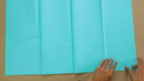 Hands spread and count blue tissue paper on flat surface for craft Stock Footage 284412439