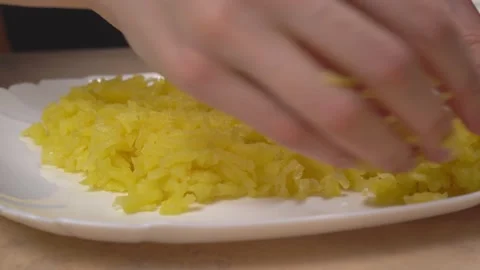 Hands spread boiled grated potatoes on a white plate Video stock 151209330