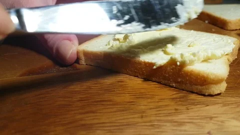 Hands spread cheese on bread Video stock 83957882