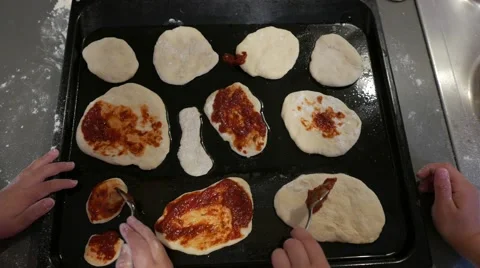 Hands spread the tomato sauce with spoons on Pizza Stock Footage 56758670