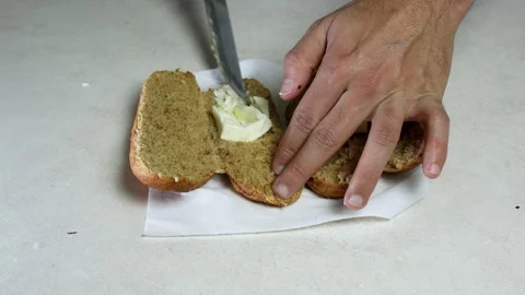 Hands Spreading Butter On Brown Bread Roll Stock Footage 342607259