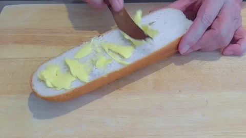 Hands Spreading Butter on Fresh Bread Stock Footage 345227259