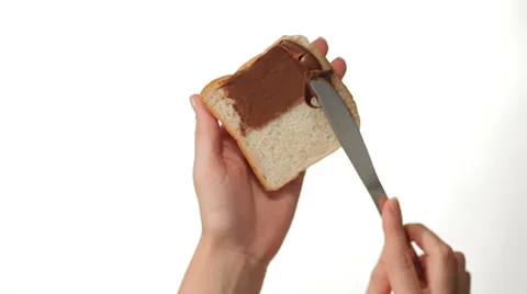 Hands spreading Chocolate Cream on a Slice of Toast Vidéo 27121593