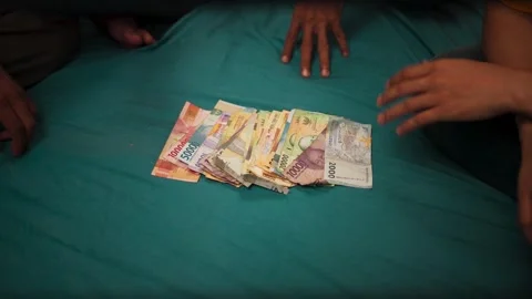 Hands spreading indonesian rupiah banknotes on table Stock-Footage 345860963