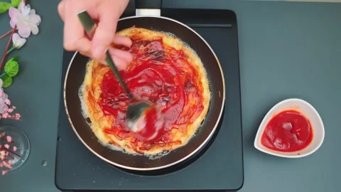 Hands spreading ketchup on fried potato pancake in kitchen Stockbeeldmateriaal 342882664