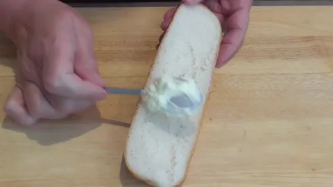 Hands Spreading Soft Cheese on Fresh Bread Stock Footage 345227253