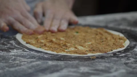 Hands spreading spicy minced meat on thin dough for traditional turkish lah.. Stock Footage 332893087