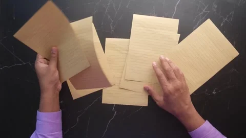 Hands spreading vintage brown lined papers on black marble background in mo.. Stock Footage 332407733