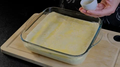 Hands Sprinkling Breadcrumbs into Casserole Dish in Cooking Scene Video stock 341452882