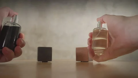 Hands sprinkling eau de parfum into air. Grunge style bottles at post modern Video stock 170613585