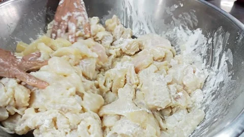 Hands sprinkling flour over raw fish pieces in a bowl. Video stock 342517120