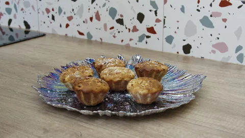 Hands sprinkling sugar powder on muffins on a plate. Stock Footage 266426953