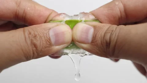 Hands squeezing the Aloe vera gel from green aloe vera leaf. Stock Footage 232940045