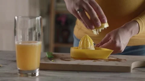 Hands Squeezing Fresh Organic Lemons. Lemon is pressed on with hand juicer. Stock Footage 265839421