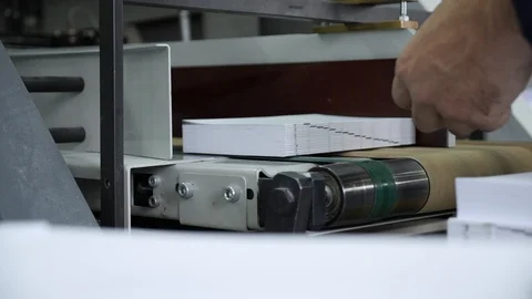 Hands stack the paper pages of the future book on the conveyor in the typography Stock Footage 98119380