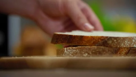Hands Stacking Freshly Sliced Whole Grain Bread in Bakery Setting 스톡 동영상 329509274