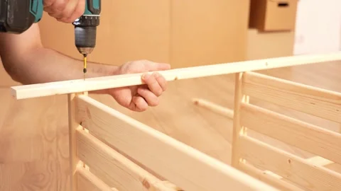 Hands steady a wood plank while drilling Stock Footage 342423891
