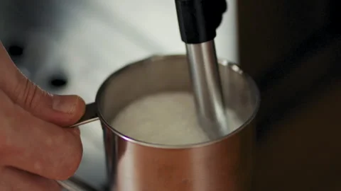 Hands Steaming Fresh Milk in Stainless Steel Pitcher 库存影片 346636474