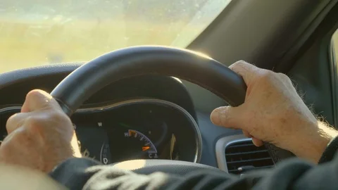 Hands on steering wheel driving into sun Stock Footage 112365108