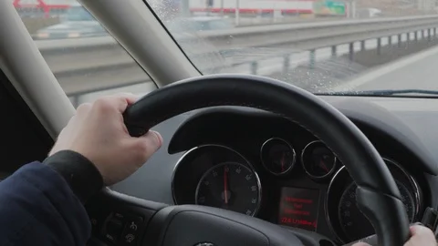 Hands on steering wheel during car driving on rush day road Stock Footage 102938734