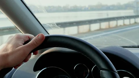 Hands on steering wheel during driving on bridge cross lake Stock Footage 106060577