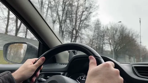 Hands on the steering wheel, a man driving a car on the road 스톡 동영상 220865467