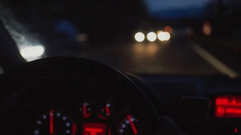 Hands on steering wheel, night lighting of oncoming traffic Stock Footage 103099462