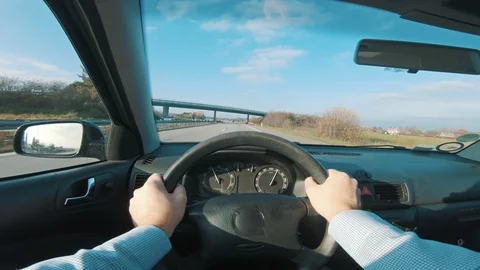 Hands on the steering wheel in point of view shoot in car on freeway Stock Footage 98658721