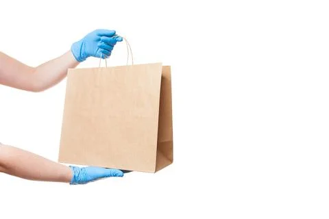 Hands in sterile gloves of a courier for the safe delivery of food. Stock Photos
